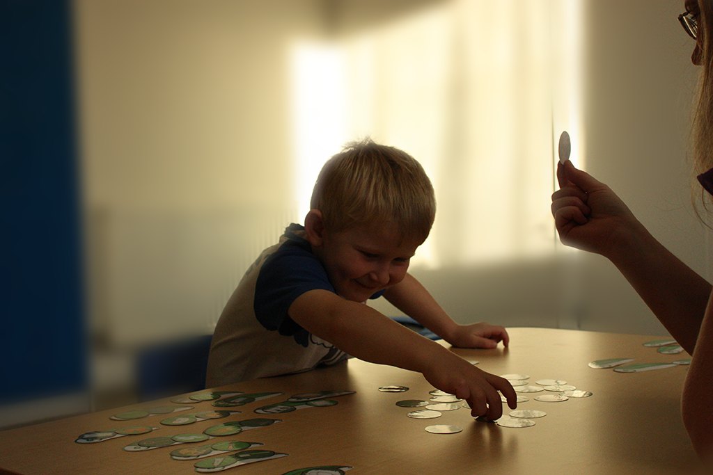 A young boy choosing a picture card from a table