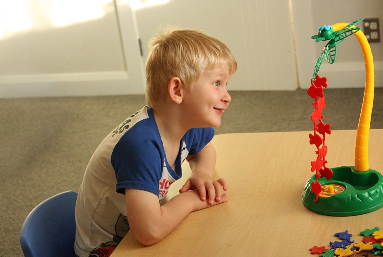 A young boy concentrating on an activity at a table